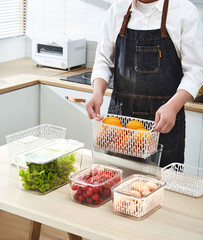 Man in apron preparing fresh fruit salad in the kitchen at home, female hands with plastic...