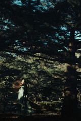 Obraz premium Asian female model in serene forest with traditional fan.