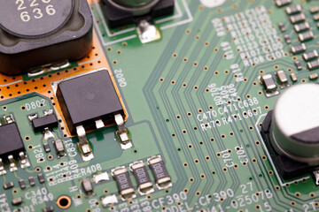 Detailed macro photo of a green printed circuit board showing transistors, resistors, capacitors,...