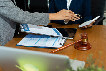Lawyer team or accounting department writes a note and uses a calculator to calculate expenses -...