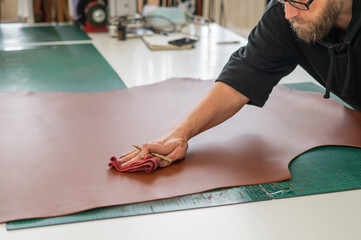 Caucasian bearded man working as a tanner in a workshop. 