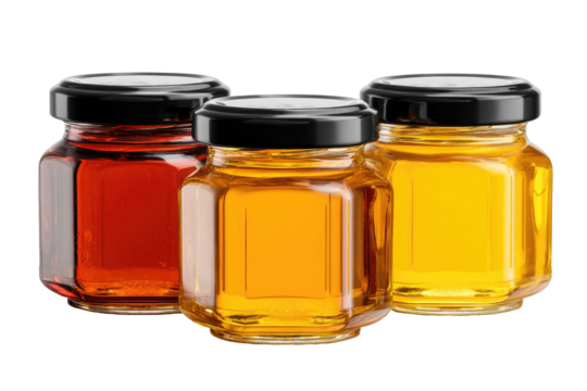 Three small, octagonal glass jars, filled with different colored honey,  with black lids
