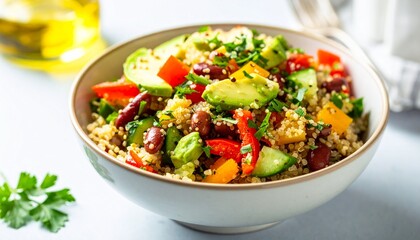 Healthy homemade quinoa salad with avocado, kidney beans, and fresh vegetables in a white bowl
