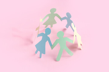 Paper human figures on pink background