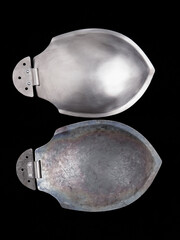 Shiny steel shoulder armor plates with hinge detail, shown front and back on black background.