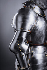 Naklejka premium View of a medieval steel armor showcasing precise craftsmanship, durable construction, and intricate rivet detailing, evoking historical eras of chivalry and protection in a battlefield setting.