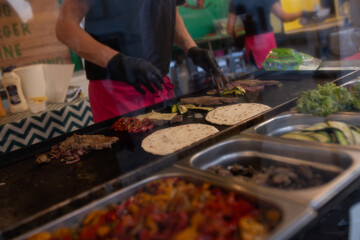Street food vendor preparing piadina with meat and vegetables