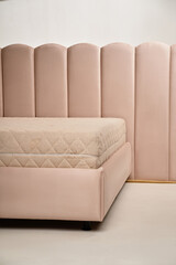 Interior setup featuring a comfortable bed with a pink upholstered headboard and matching base,...