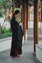 Young Asian woman in traditional clothing in serene setting Chinese word means serene.
