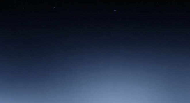A serene view of the deep night sky with a few faint stars, showing a dark blue gradient to a light haze on the horizon.