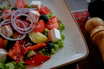 A Colorful Salad Featuring Fresh Vegetables, Feta Cheese, Olives, and Topped with Red Onions Served in an Elegant Bowl