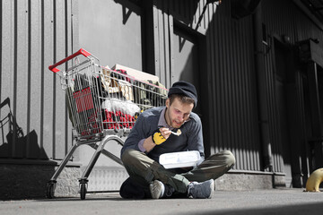 Homeless man eating food on street