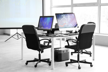 Interior of trader's office with desk and projector screen