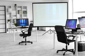 Interior of trader's office with desks and projector screen