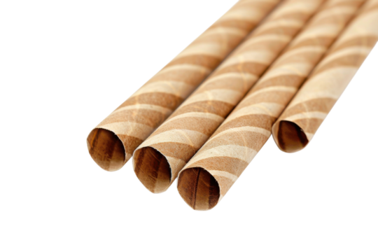 Decorative paper straws in brown and white color resting on a surface for eco-friendly parties or drinks
