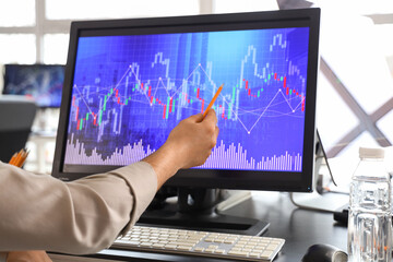 Hand of male trader working with exchange rates in office, closeup