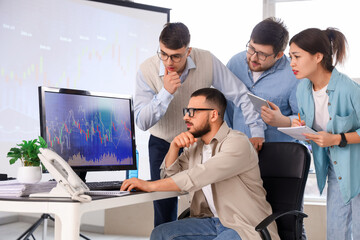 Team of traders working at table in office