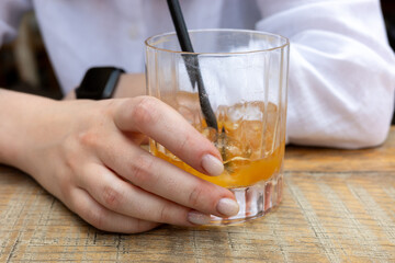 Enjoying a refreshing cocktail with ice on a wooden table