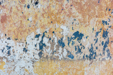 Aged wall texture with peeling paint, showcasing a mix of colors and a weathered look.