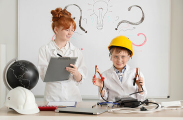 Cute inventors with battery tester in laboratory