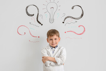 Cute inventor near whiteboard with drawn light bulb and question marks