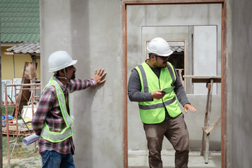 Asian or Indian architect foreman male working control communicate with builder using walkie-talkie...