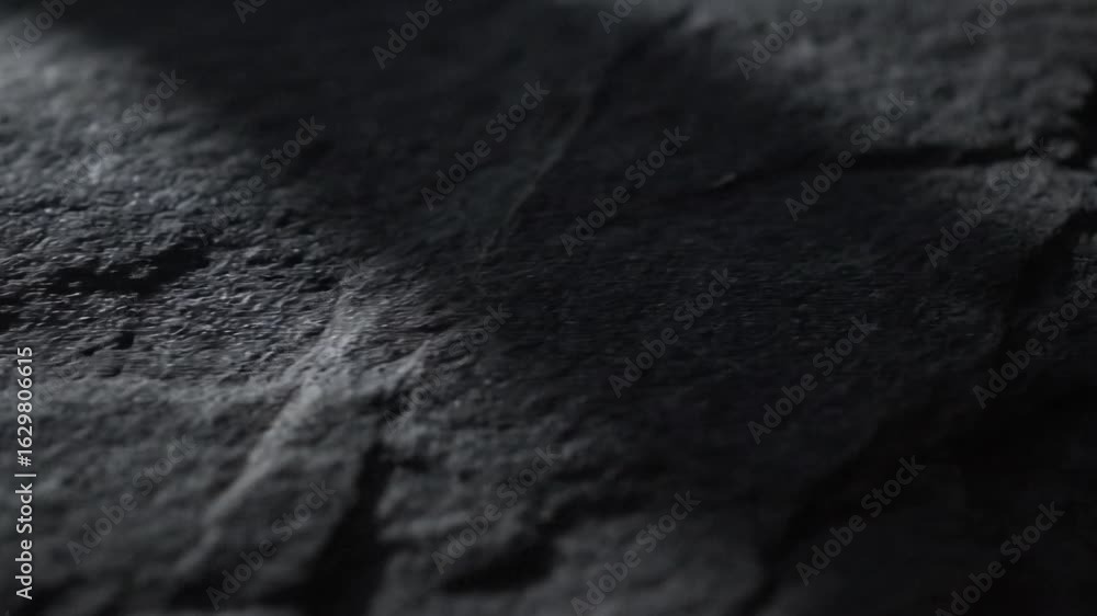 Poster dark gray surface with textures showing variations in lighting and shadow