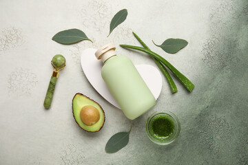 Composition with bottle of cosmetic product, plaster podium and ingredients on green grunge...