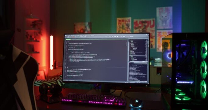 Static Footage with a Gaming Personal Computer with a Source Code on Display Standing on a Table in a Stylish Neon-Lit Room. No People in the Shot, Software Developer Nowhere to Be Seen