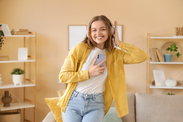 Beautiful young woman listening to music  and dancing at home