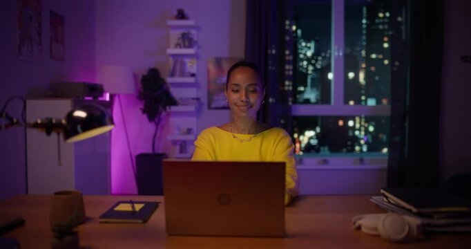 Cheerful Black Female Opening Up a Laptop and Starting to Work. Portrait of a Beautiful African Girl Sitting Behind a Table at Home in a Living Room, Using Computer. Dynamic Robot Camera Footage