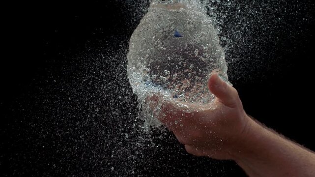 Slow Motion Of Water Balloon Bursting In Bare Hand