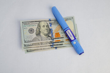 Basra, Iraq - August 5, 2025: A Saxenda Pen Resting on a Stack of American One Hundred Dolla