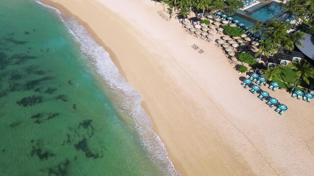 Aerial view of tropical beach with swimming pool and beach umbrellas, Nico beach, Nusa Dua, Bali, Indonesia