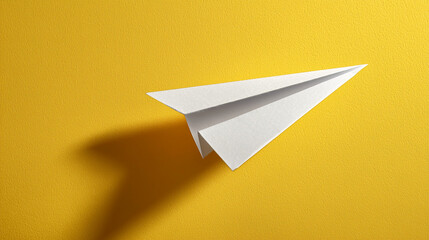 white paper aeroplane on yellow background
