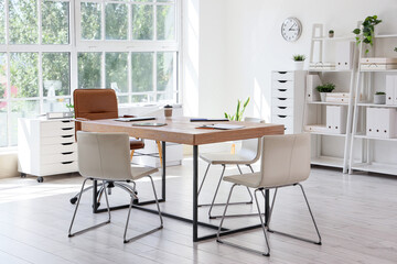 Interior of conference hall with table, shelf units and plants