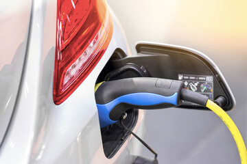 Electric car charging on parking lot with electric car charging station on city street. Close up of...