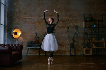 An elegant ballet performance in a modern studio showcases artistry and grace in every move