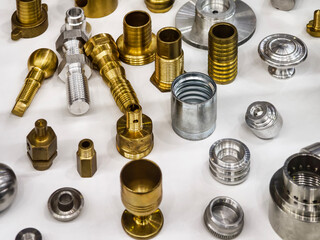 Variety of metal components in different finishes arranged on a work surface for inspection and...