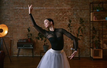 Elegant female dancer in an artistic pose set against a striking urban background
