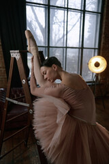 A ballet dancer performs on a ladder, showcasing her exquisite stretch and graceful artistry