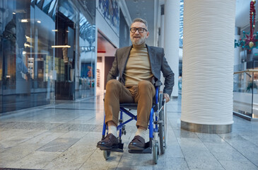 A man sitting in a wheelchair while he is inside a mall