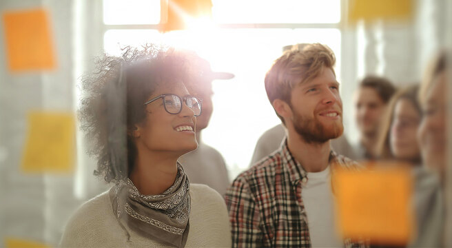 A modern office scene with a collaborative team brainstorming behind a glass wall covered in bright yellow sticky notes, symbolizing creativity, planning, teamwork, and productivity in a professional 