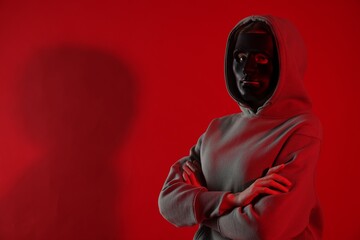 Anonymity. Woman wearing mask on red background, space for text