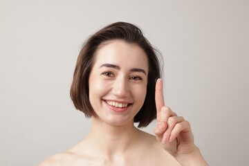 Woman with contact lens on light background