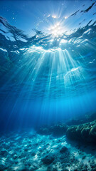 Fototapeta premium Sunlight beams piercing the clear blue ocean water from above