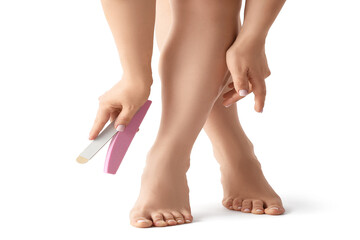 Feet of young woman with fresh pedicure and nail files isolated on white background, closeup