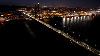 Fototapeta premium Night 25Th April Bridge In Lisbon Portugal. Aerial View Of Landmark Bridge Showcasing Its Intricate Design . Building Infrastructure Landscape Buildings Vibrant. Infrastructure Corporate.