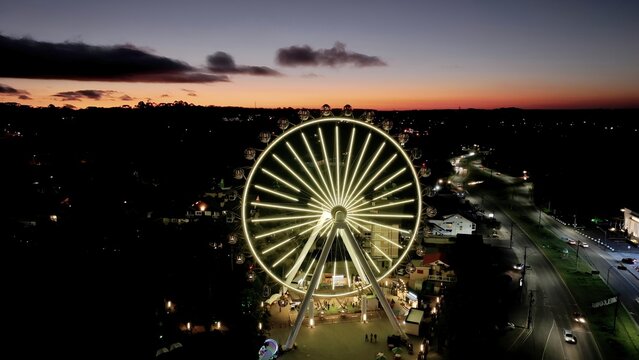Sunset Emoji Smile In Canela Rio Grande Do Sul Brazil. Ferris Wheel Shining Over Downtown District Landscape. Building Landscape Skyscrapers Stunning. Industry Urban Corporate.