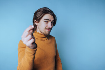 portrait of young man playfully gestures with his fingers, conveying curiosity and a light-hearted...